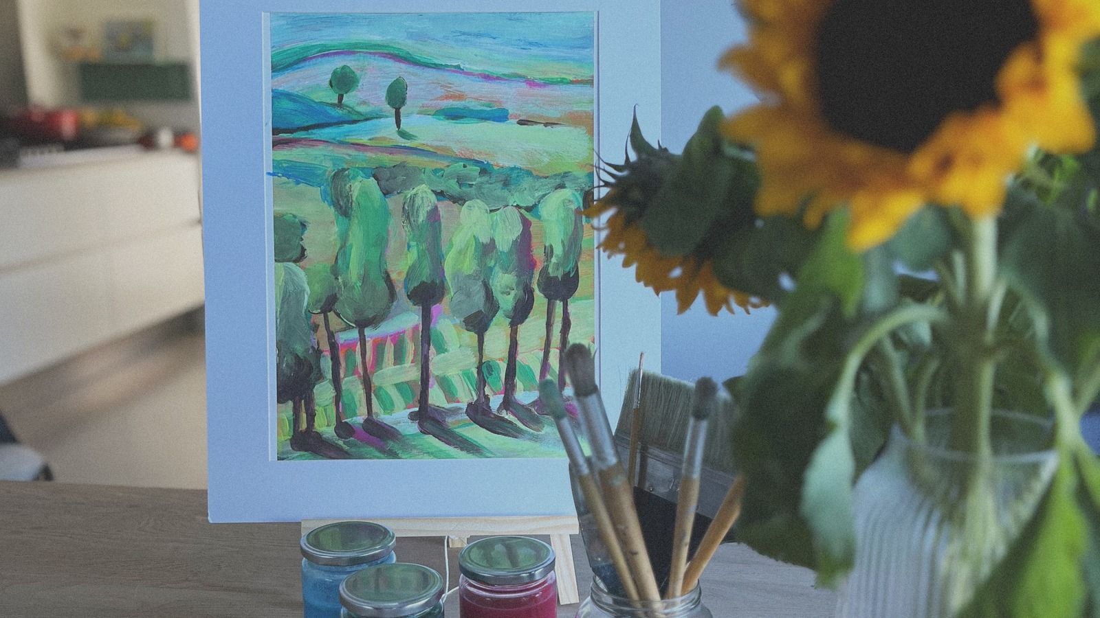 Schilderij en zonnebloem op tafel
